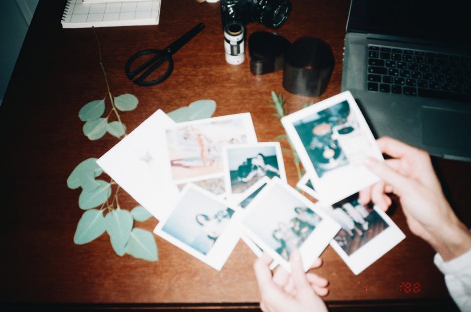 A nostalgic collection of instant photos displayed on a wooden desk, capturing cherished memories.